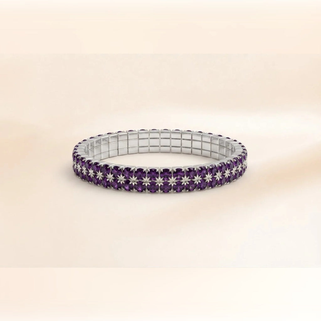 A silver-toned stretch bracelet featuring rows of deep purple round-cut gemstones and starburst-shaped purple and silver pavé accents, displayed on a soft beige background.