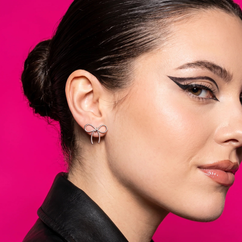 Side profile on ear: Silver Twisted Bow Stud Earrings