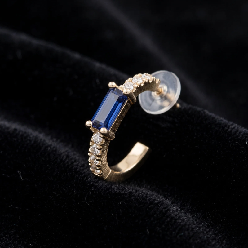 Close-up detail of Gold Sapphire Baguette Huggie Earrings
