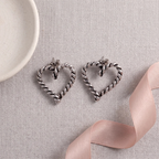 Flat lay of Silver Twisted Rope Heart Earrings