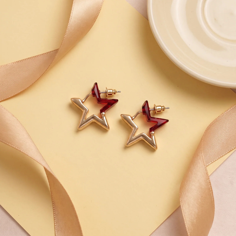 Flat lay of Ruby Élan Star Earrings