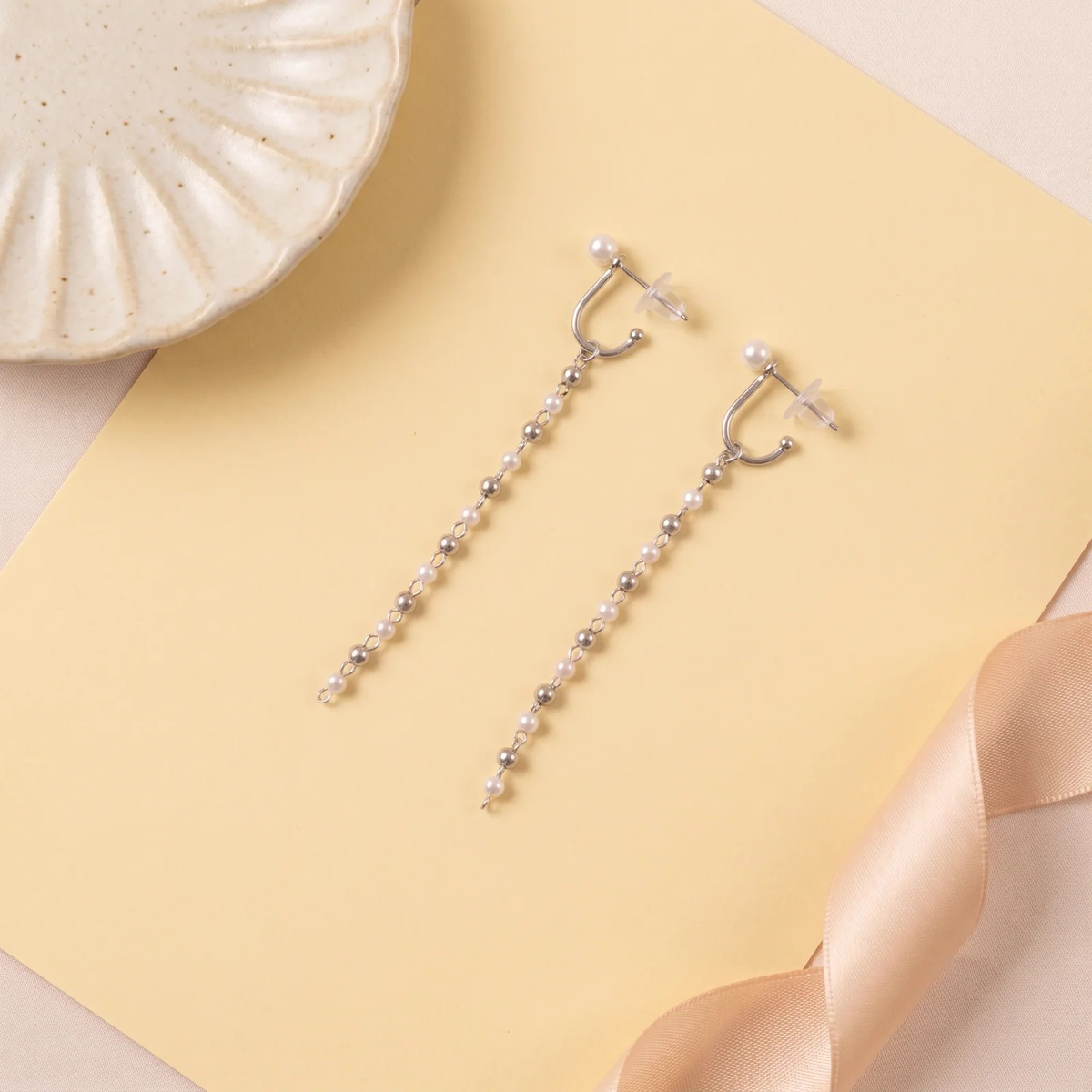Flat lay of Cascade Pearl Drop Earrings