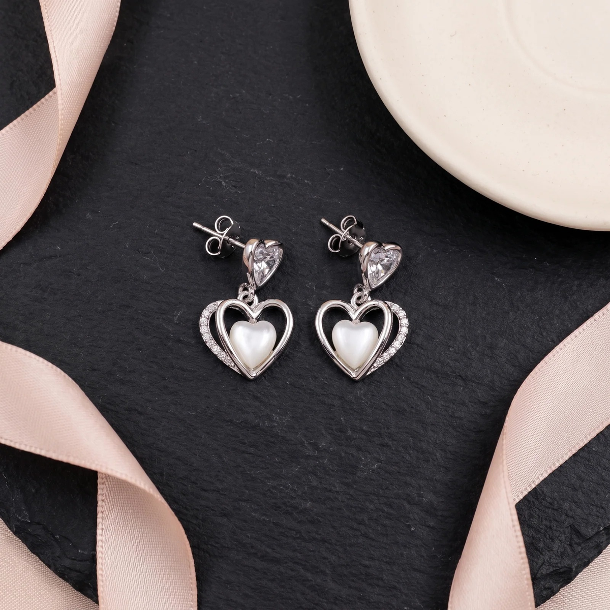 Flat lay of Double Heart Crystal Drop Earrings