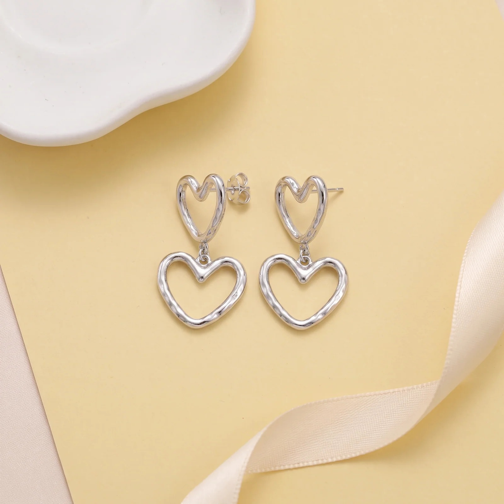 Flat lay of Double Heart Outline Drop Earrings