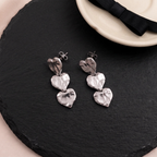 Flat lay of Triple Heart Drop Earrings
