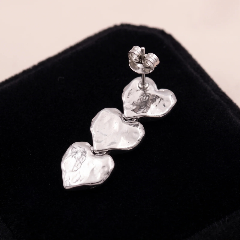 Close-up detail of Triple Heart Drop Earrings