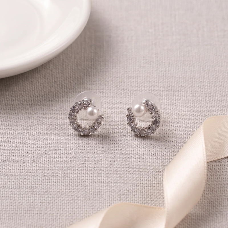 Flat lay of Crystal Crescent with Pearl Stud Earrings