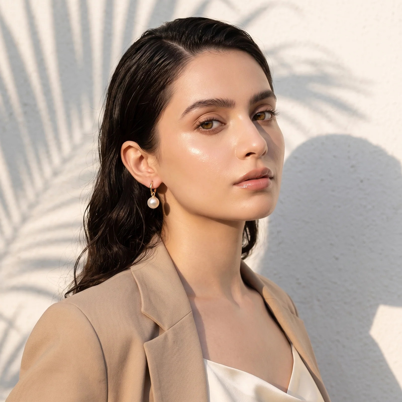 Side profile on ear: Gold Pearl Huggie Hoop Earrings