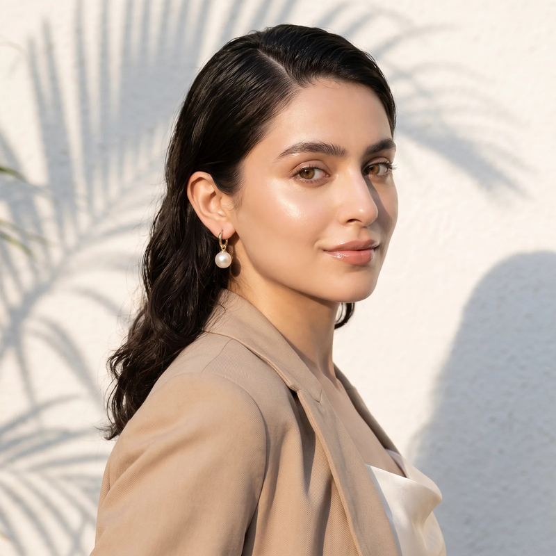 Model wearing Gold Pearl Huggie Hoop Earrings