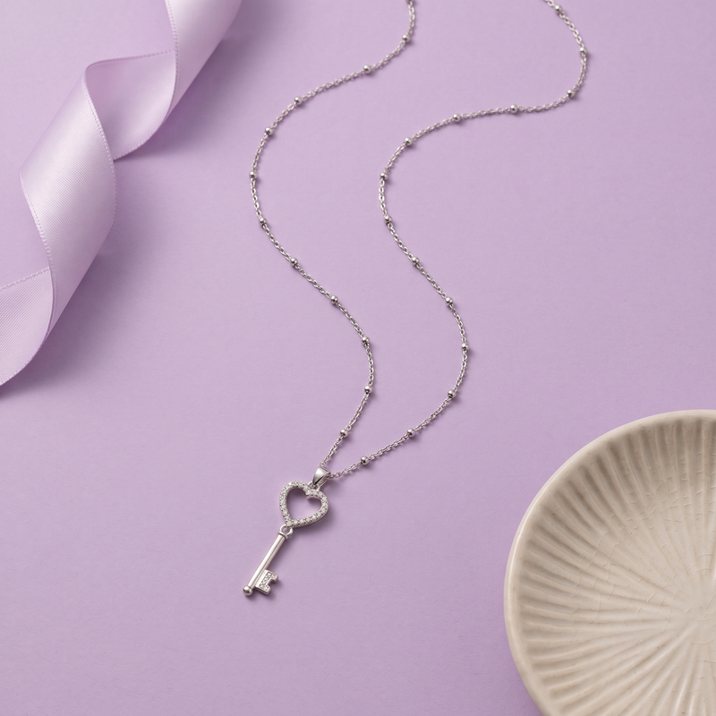 Flat lay of Heart & Key Pendant Necklace