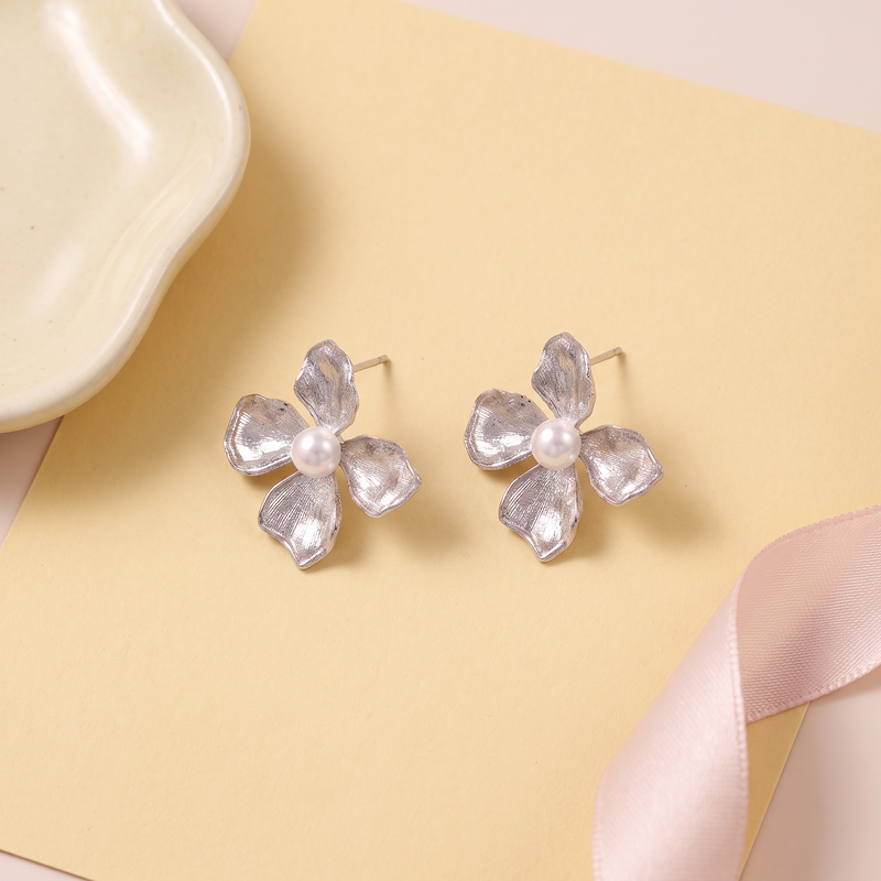 Flat lay of Silver Floral Pearl Stud Earrings